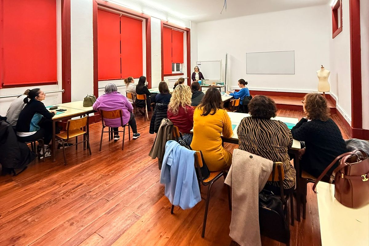Sala de formação da sede, com formandos sentados às mesas e a formadora junto ao quadro